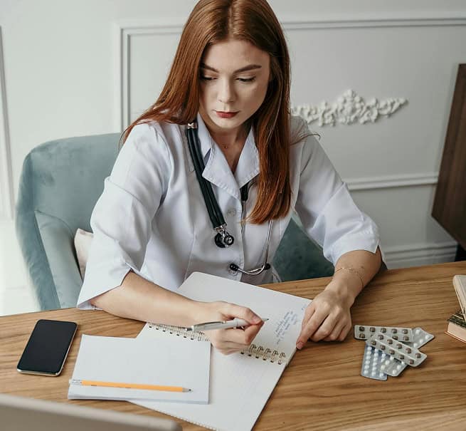 Médica escrevendo em seu caderno