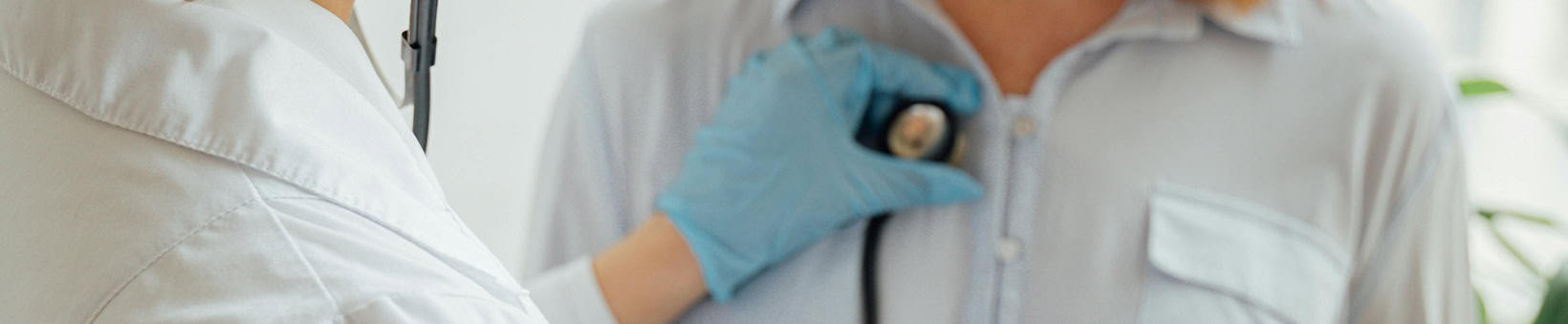 Médico ouvindo o pulmão de uma paciente de frente